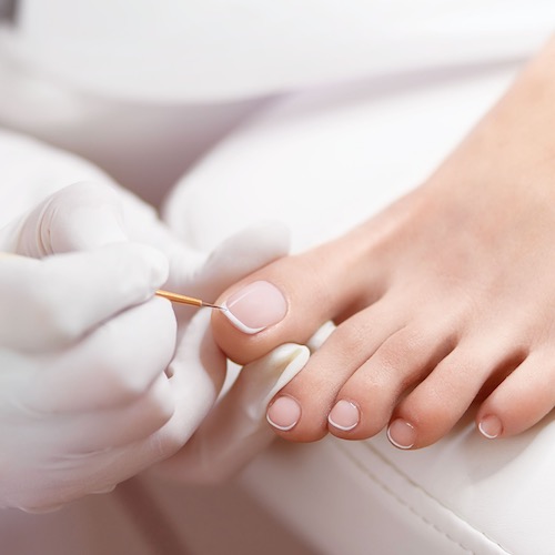 Close up shot of nail tech wearing gloves and showcasing our superior nail hygiene standards